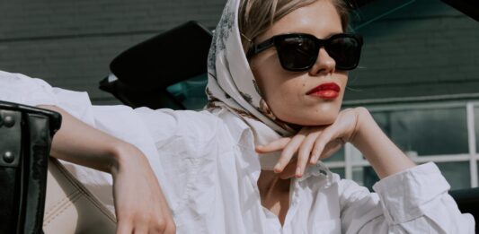 Elegancka kobieta w białej koszuli i okularach przeciwsłonecznych