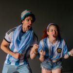 Dwaj kibice Argentyny entuzjastycznie świętują mecz w pomieszczeniu