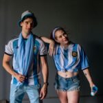 Dwóch kibiców w koszulkach Argentyny pozuje w pomieszczeniu