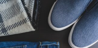 Jak stworzyć elegancką stylizację z jeansami dzięki odpowiednim torebkom, paskom i delikatnej biżuterii Flat lay: jeansy, niebieskie sneakersy i kraciasty szalik