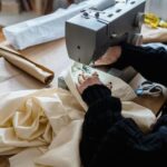 Kobieta szyje materiał na maszynie w pracowni krawieckiej
