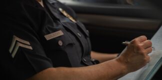 Skradziony portfel – co zastrzec i gdzie zgłosić kradzież krok po kroku? Policjant zapisujący zgłoszenie kradzieży w notatniku w radiowozie